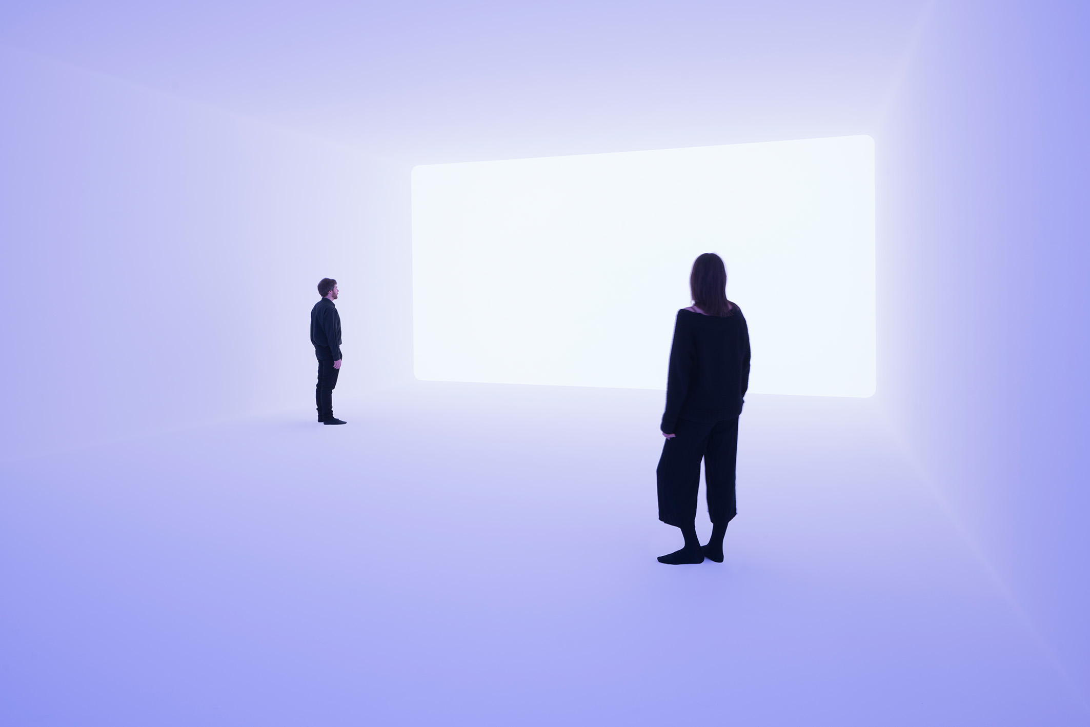 Two figures in a room of violet light, one in profile at left, one facing a bright rectangle of light